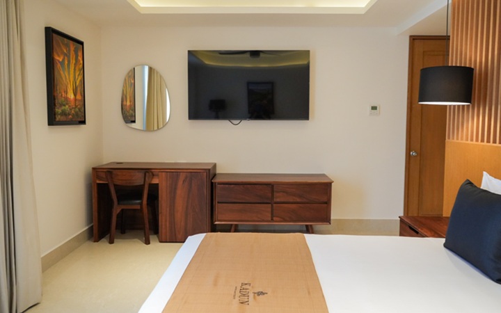 Modern workspace inside the Scenic Studio featuring a minimalist work desk, a smart TV, and an elegant accent mirror at Kadun Hotel Boutique.