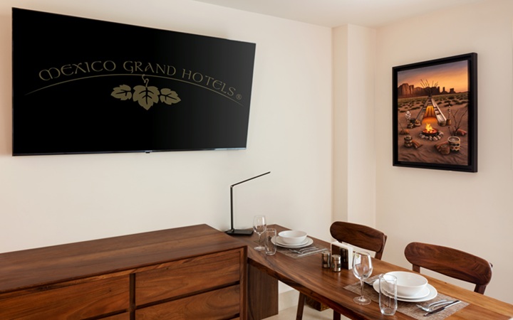 Minimalist dining area inside the luxury studio suite, showcasing a contemporary wooden table and a wall-mounted smart TV at Kadun Hotel Boutique.