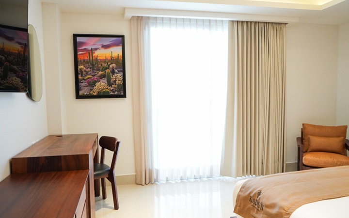 Luxury suite with private terrace featuring a built-in jacuzzi, a dedicated wooden work desk with chair, and a plush accent lounge chair at Kadun Hotel Boutique.