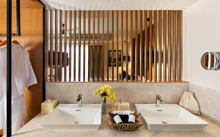 Luxury bathroom perspective highlighting double independent washbasin vanities and premium plush bathrobes at Kadun Hotel Boutique.